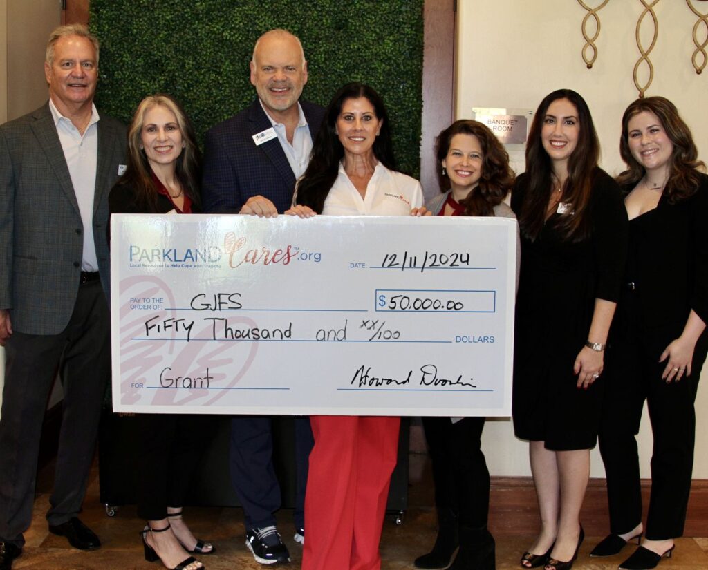 Seven supporters hold an oversized Parkland Cares check for $50,000 made out to GJFS, dated 11 December 2024.